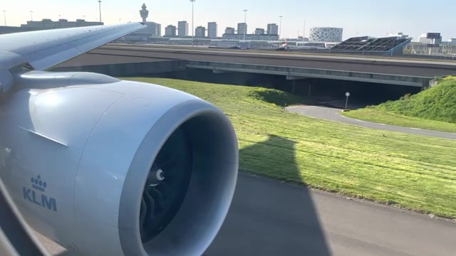 Motor van een KLM Boeing 777 tijdens het taxiën op Schiphol, met de verkeerstoren op de achtergrond, uit een video van RoopramAviation