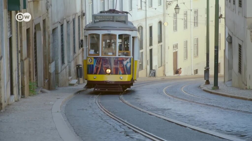 Gele tram 28 in een smalle straat in Lissabon