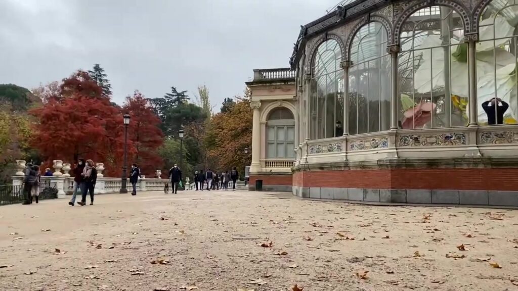 Palacio de Cristal in het Retiropark in Madrid met rode en gele herfstbomen