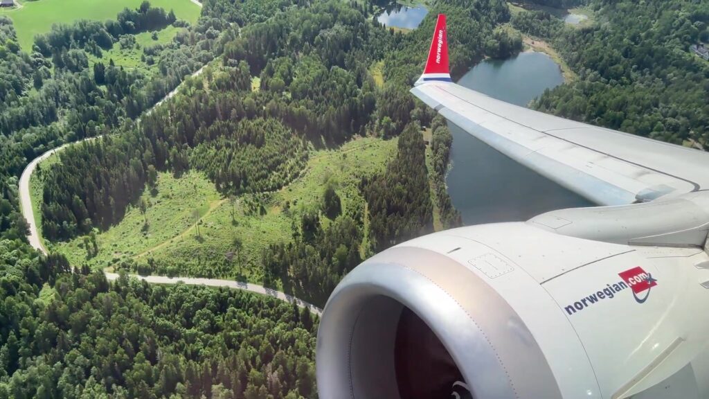 Vleugel en motor van een Norwegian-toestel kort na de start boven de bossen bij Oslo